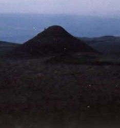 A line of glowing orbs race over a Native American shaman standing on a sacred mound (He's the small dot on left side)